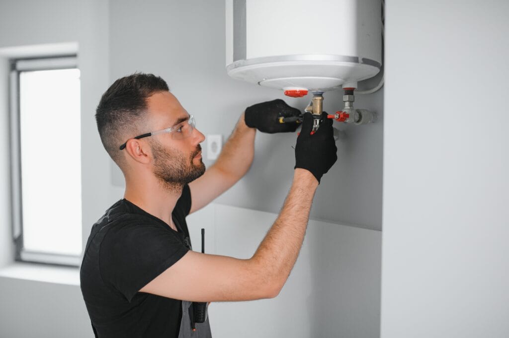 Technician performing water heater maintenance in Pueblo